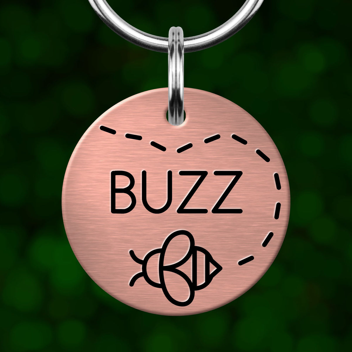 A round metal pet tag with the word "BUZZ" printed on it, featuring a bee icon.