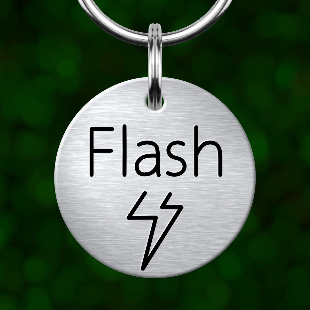 A silver metal keychain tag with the word "Flash" and a lightning bolt symbol printed on it.