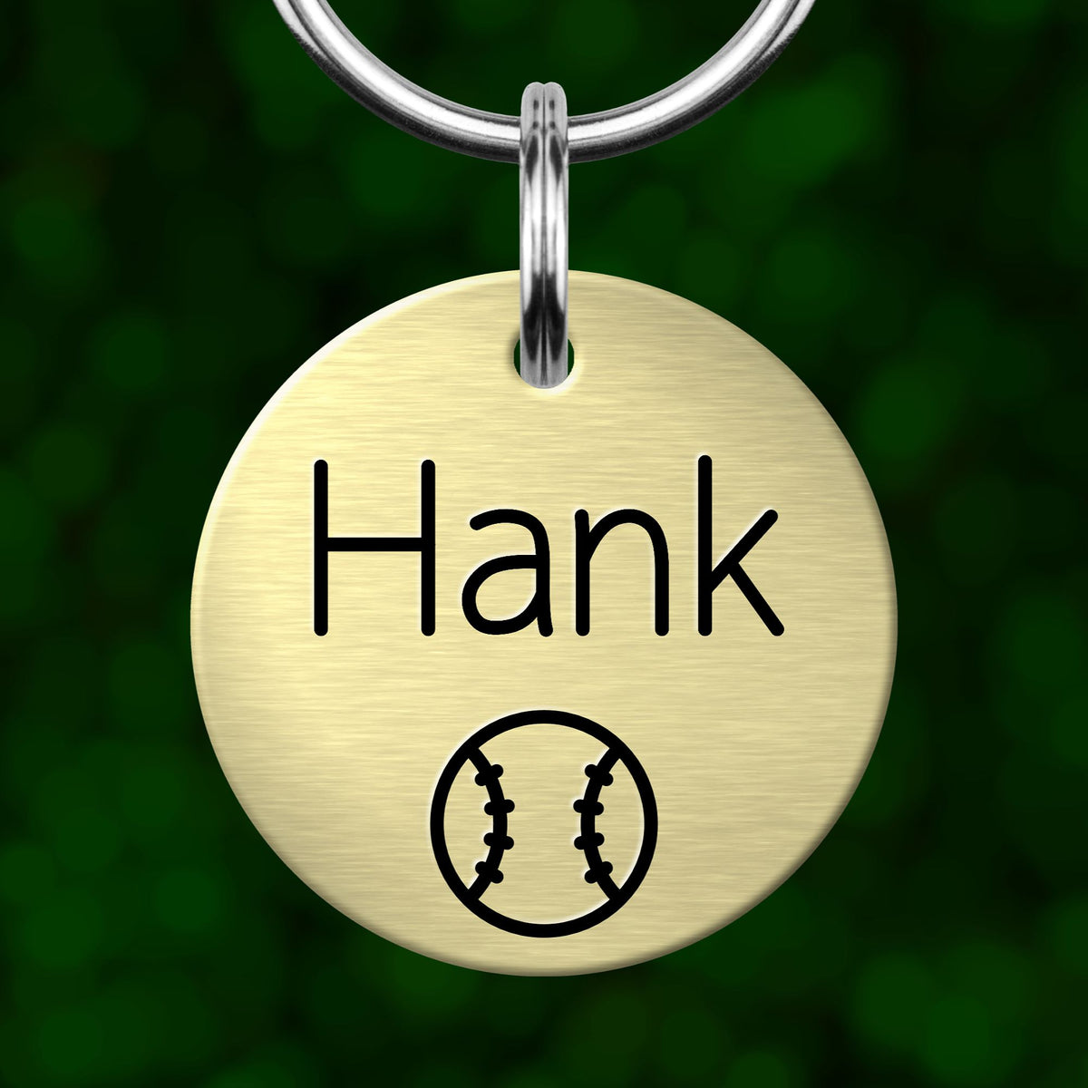 A round metal keychain tag with the name "Hank" printed on it, along with a baseball symbol.