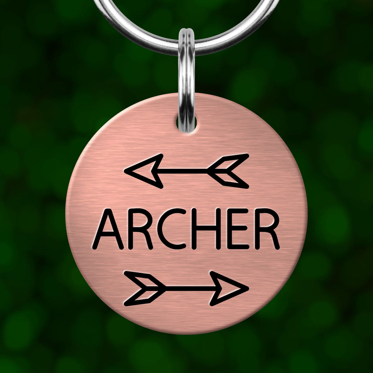 A round metal keychain tag with the word "ARCHER" printed on it, along with two arrows pointing in opposite directions.