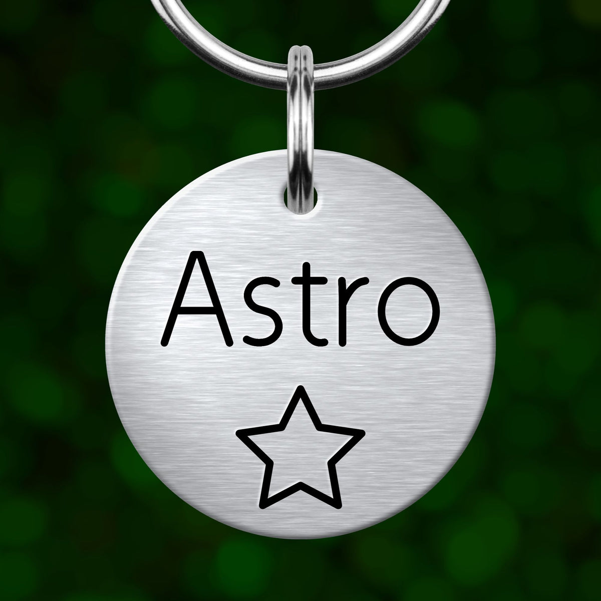 A round metal keychain tag with the word "Astro" written on it, along with a star symbol.