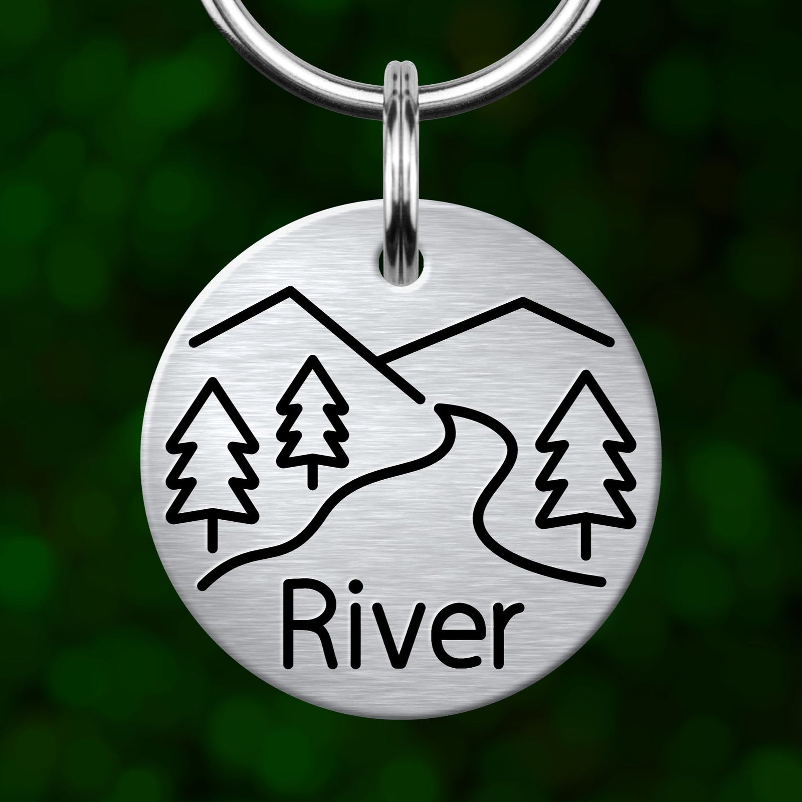 A round metal keychain with a design depicting a river and trees, with the word "River" written below the design.
