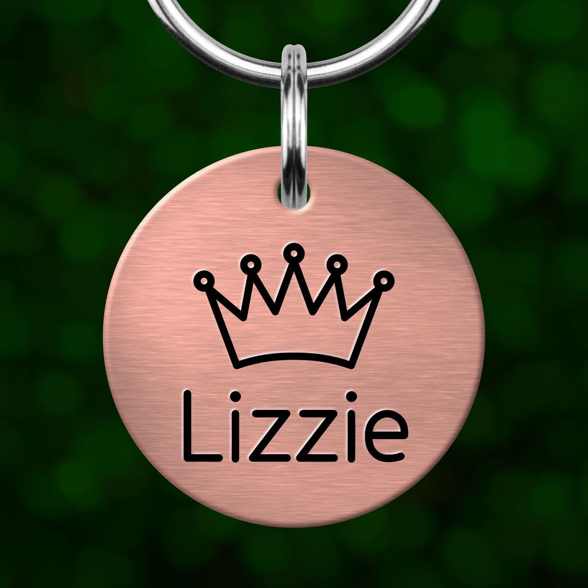 A pink metal pet tag with a crown symbol and the name "Lizzie" printed on it.