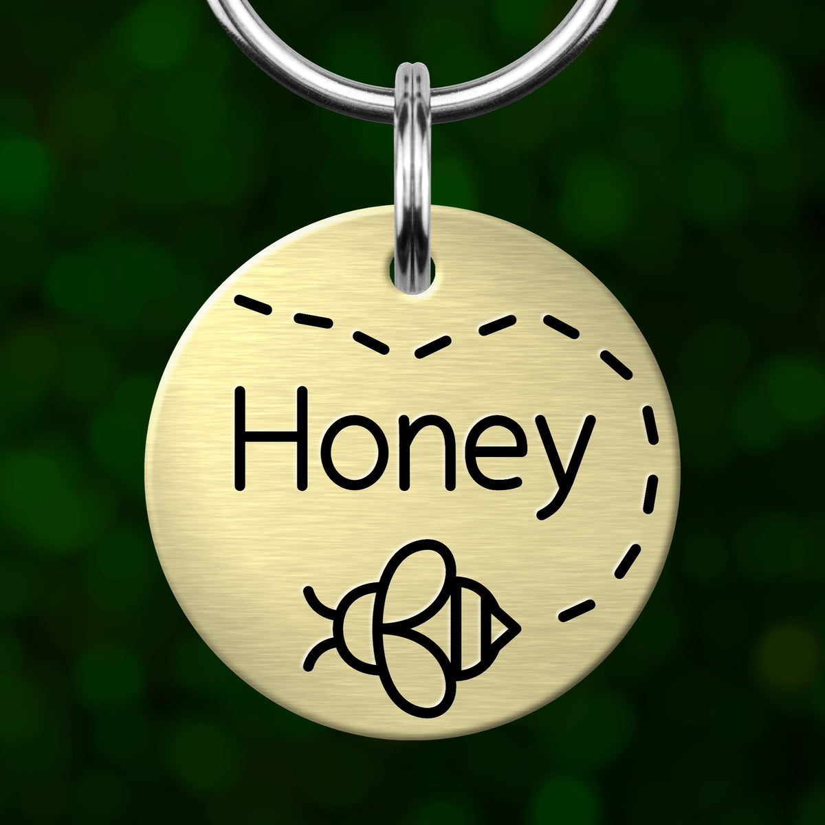 A round metal keychain tag with the word "Honey" written on it, along with a bee icon.