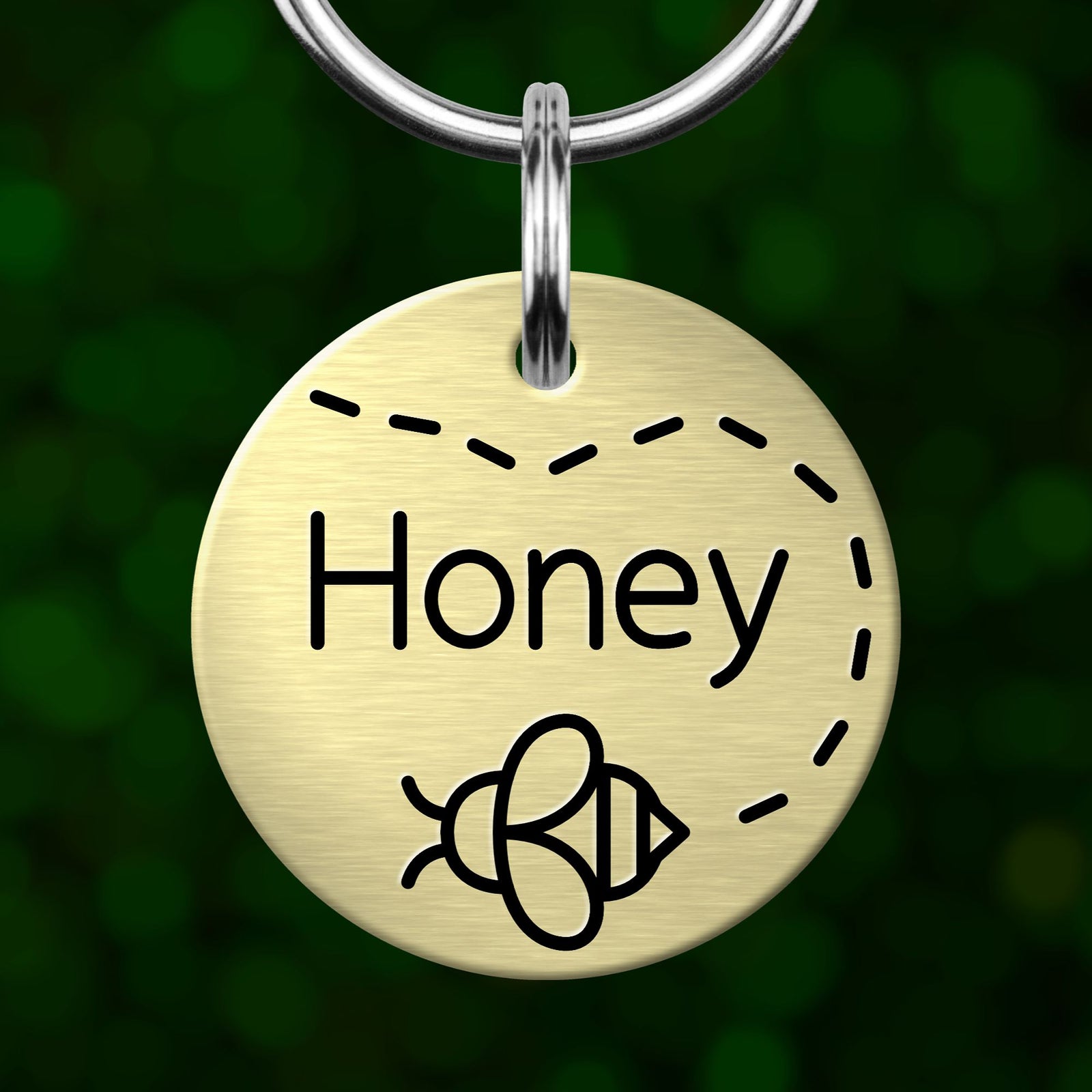 A round metal keychain tag with the word "Honey" written on it, along with a bee icon.