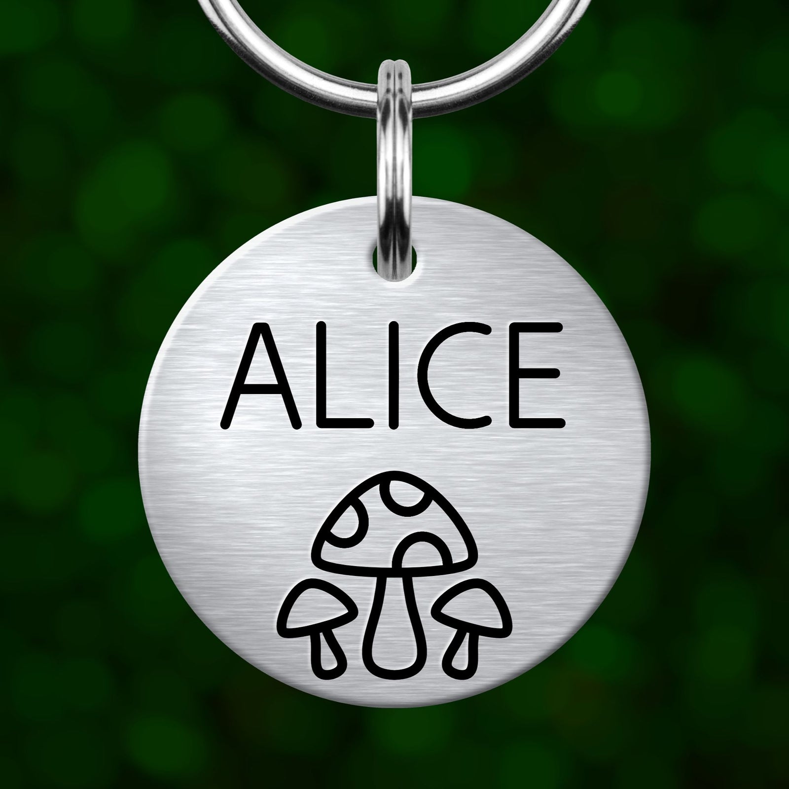 A round metal pet tag with the name "ALICE" and a mushroom icon printed on it.
