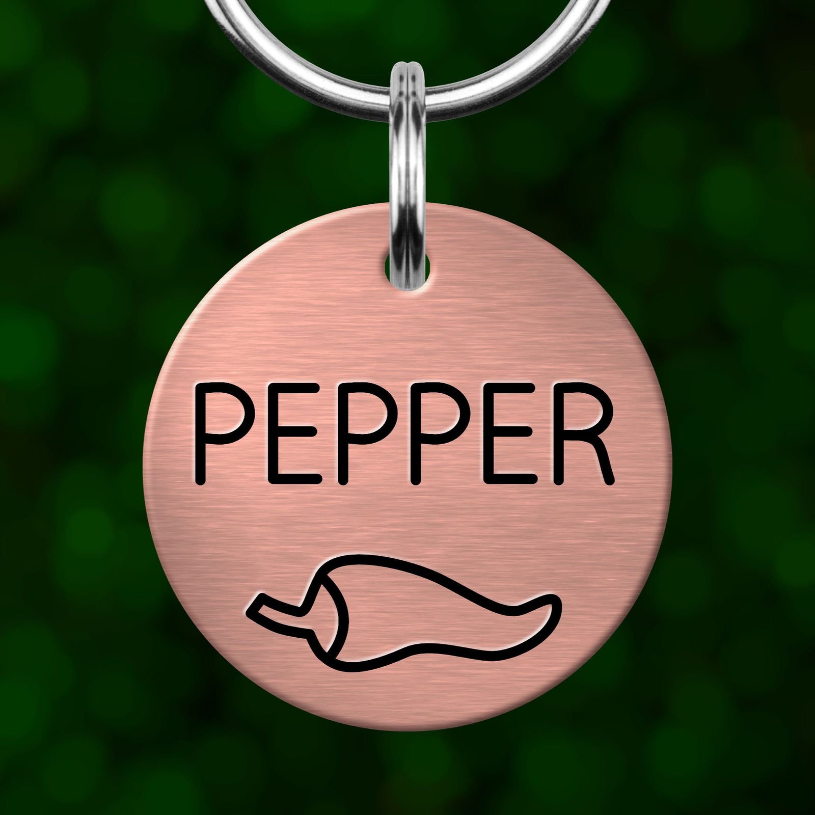 A round metal pet tag with the word "PEPPER" printed on it, along with a simple pepper icon.