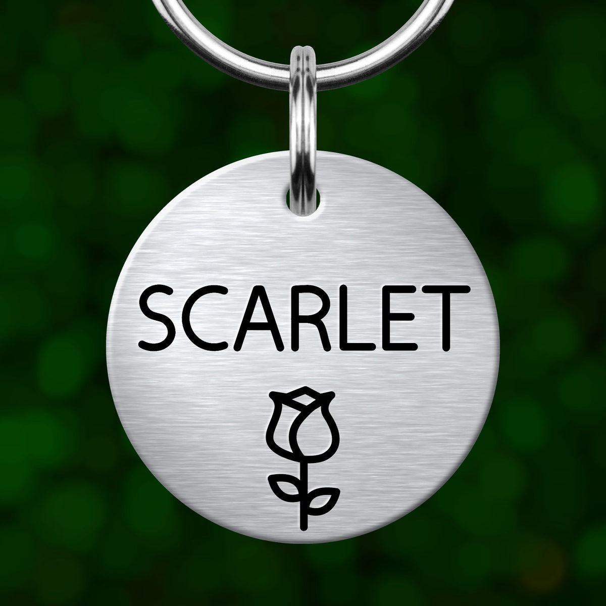 A round metal pet tag with the name "SCARLET" printed on it, with a rose symbol below the text.