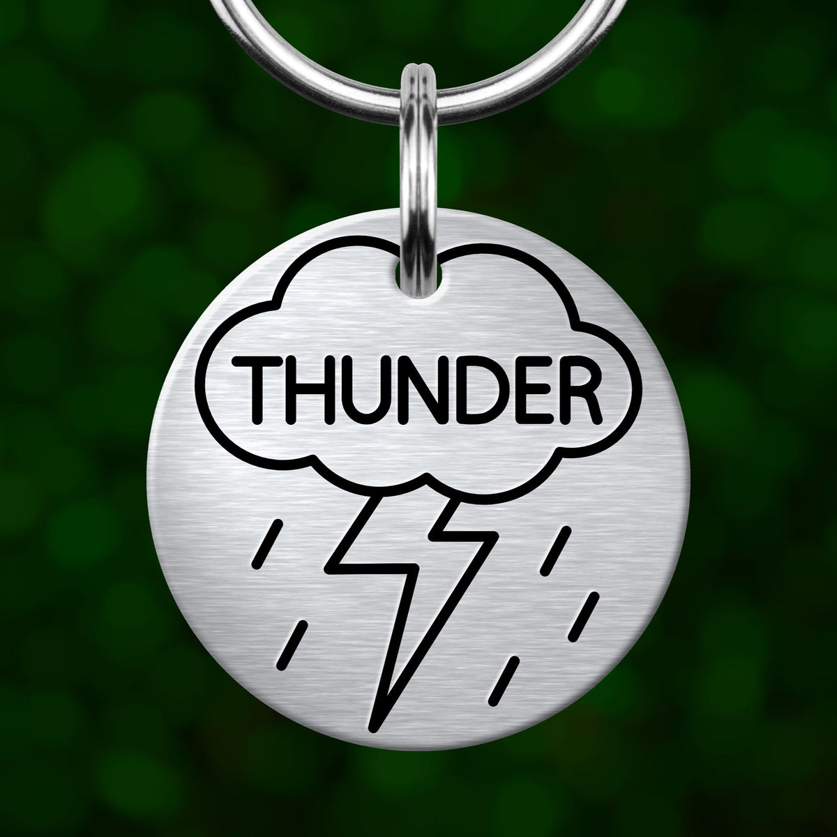A silver-colored keychain tag with the word "THUNDER" and a lightning bolt symbol printed on it.