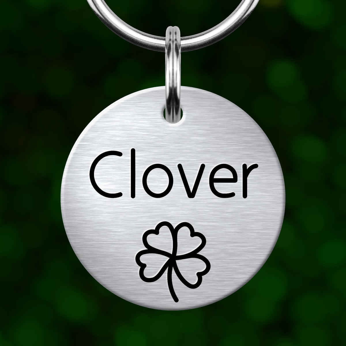 A silver-colored metal tag with the word "Clover" written on it, along with a clover symbol.