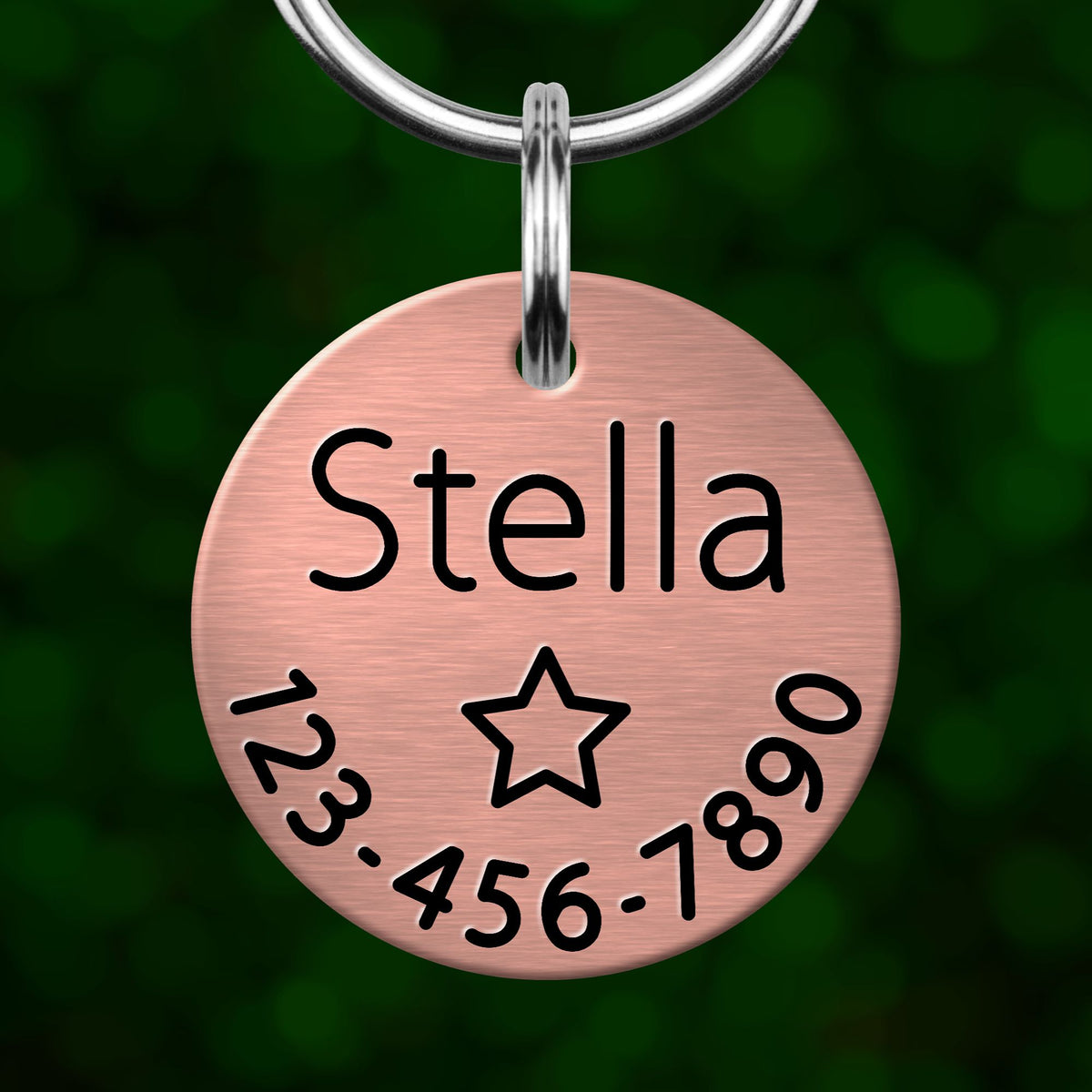 A copper-colored name tag with the name 'Stella' and a star symbol, along with a phone number.