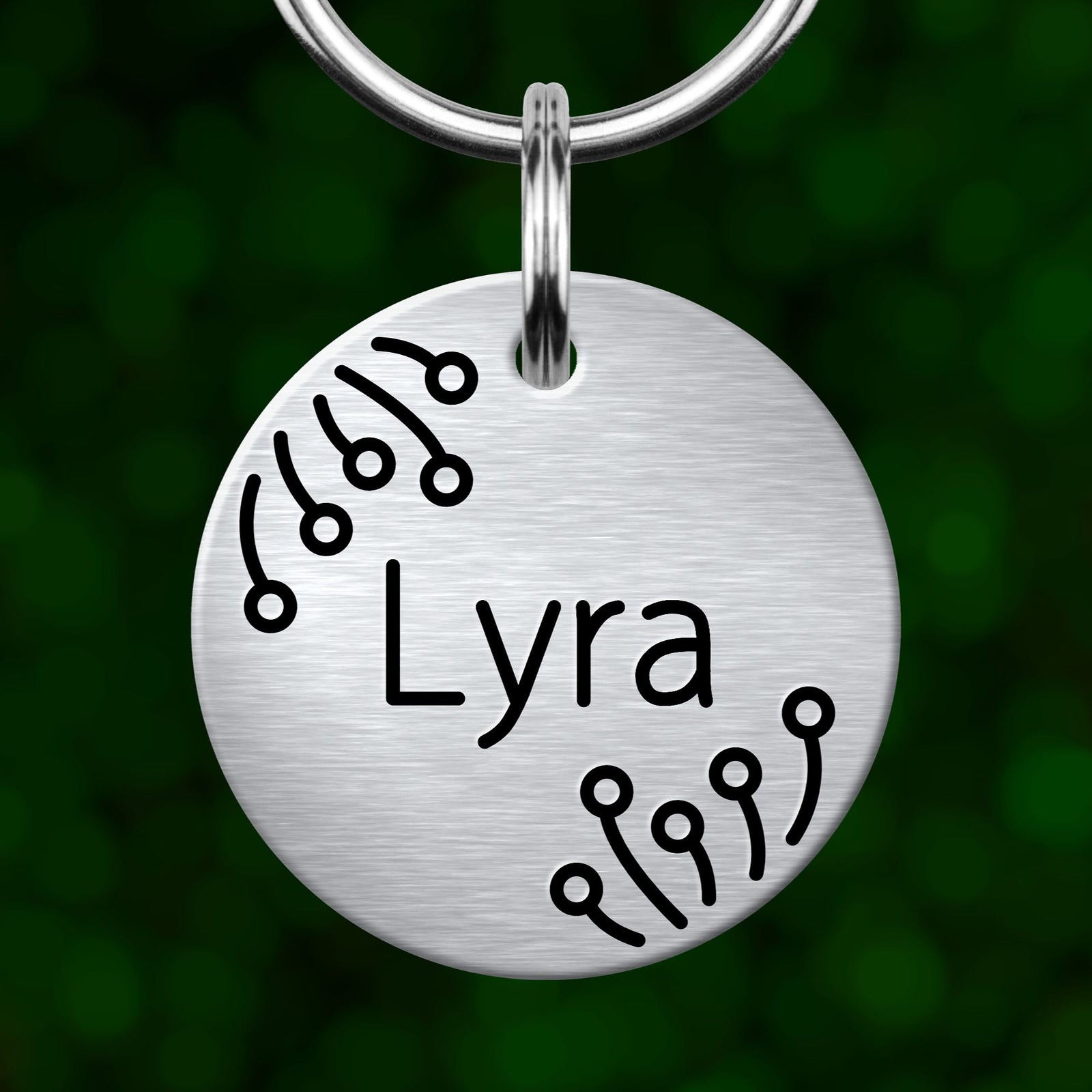 A silver circular tag with the name "Lera" engraved on it, hanging from a keychain.