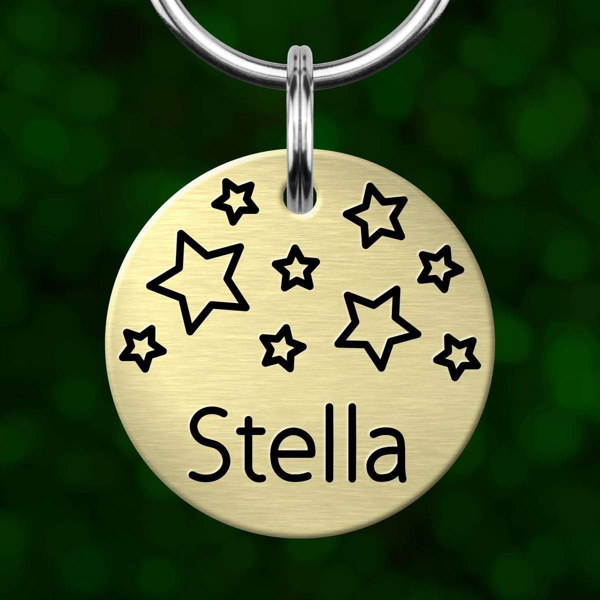 A round metal pet tag with the name 'Stella' printed on it, featuring a star-shaped design.