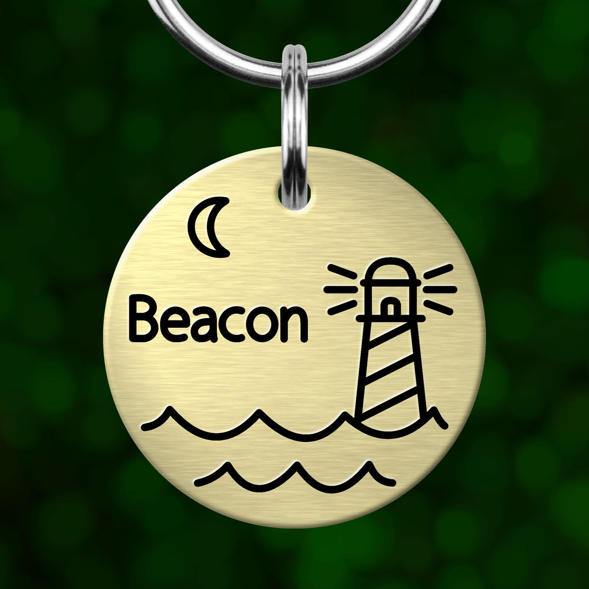 A round metal keychain tag with a lighthouse and waves design, and the word "Beacon" written on it.
