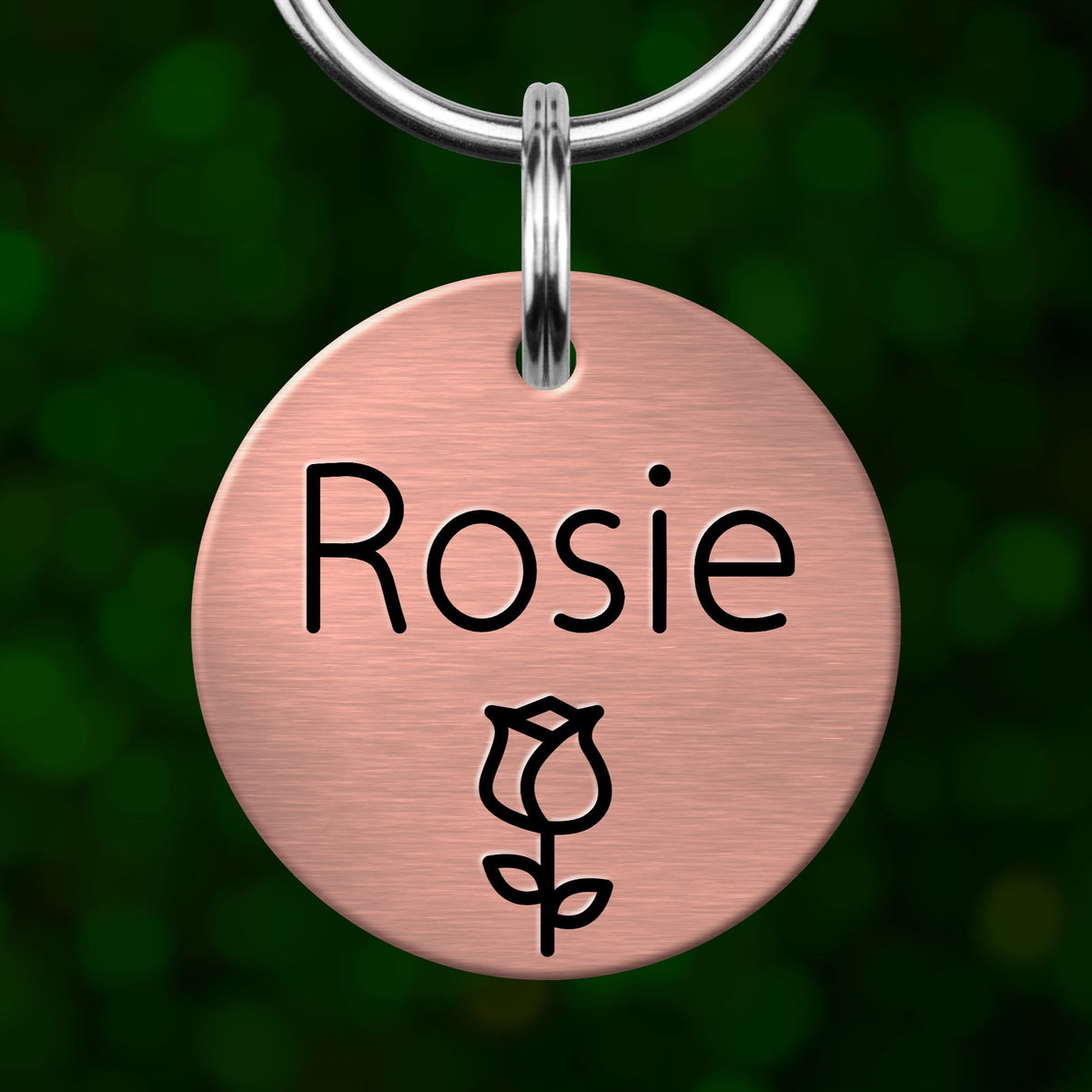 A round metal pet tag with the name "Rosa" printed on it, with a rose symbol below the text.