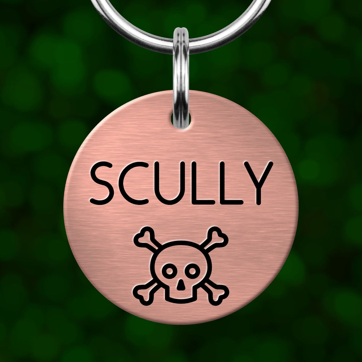 A round metal pet tag with the name "SCULLY" and a skull and crossbones symbol.