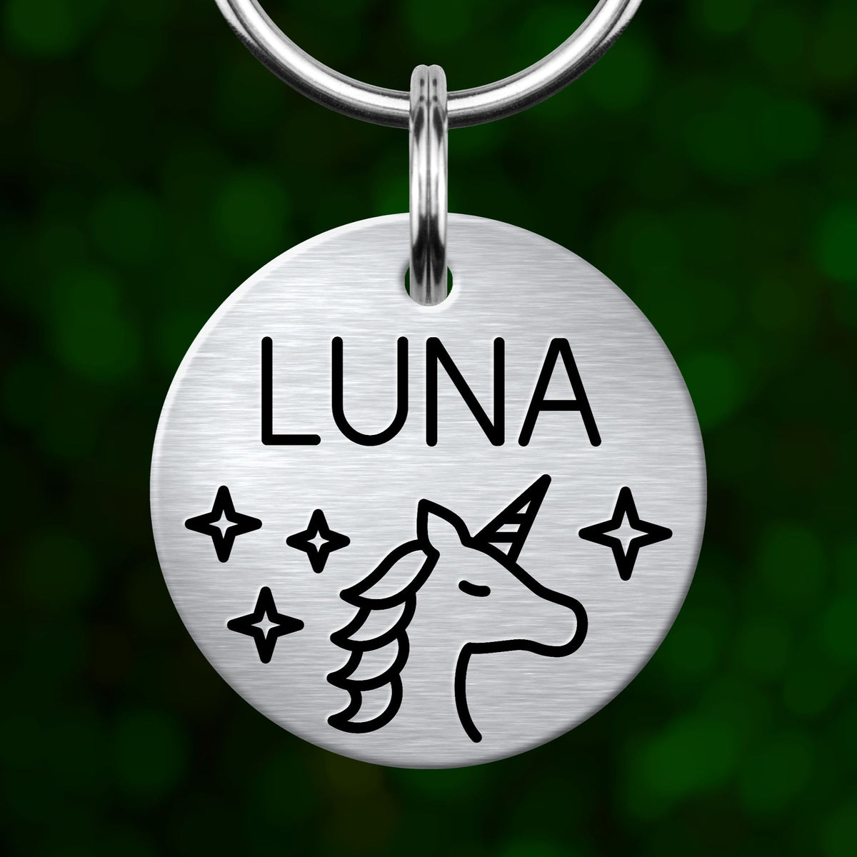 A silver-colored metal pet tag with the name "Luna" and a unicorn illustration.