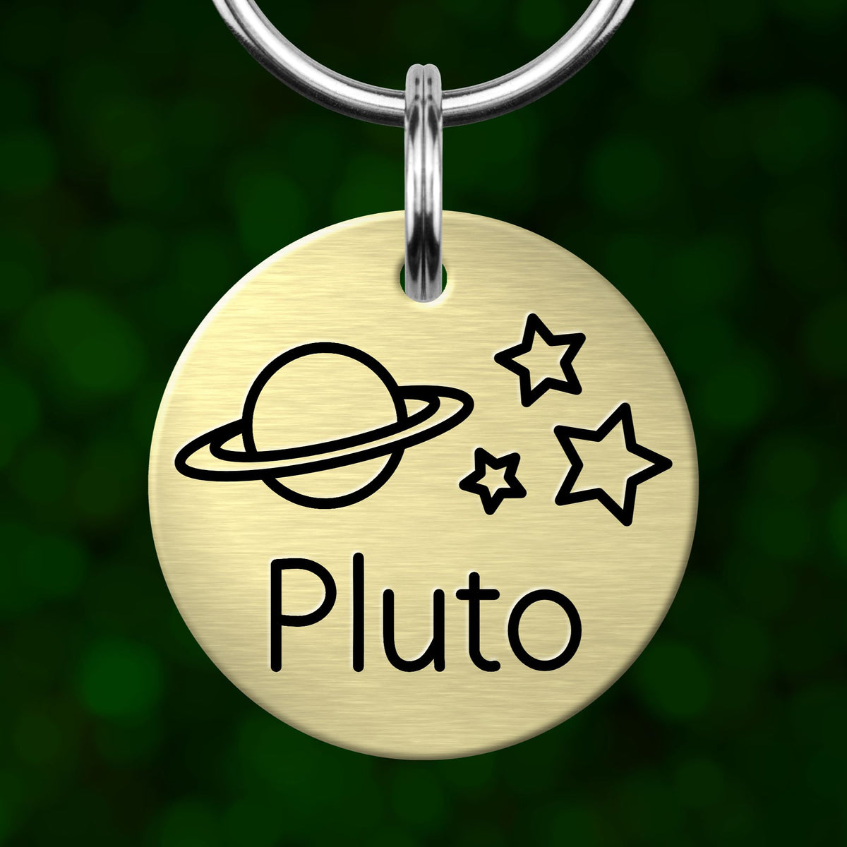 A round metal keychain tag with a planet and stars design, and the name "Pluto" written on it.