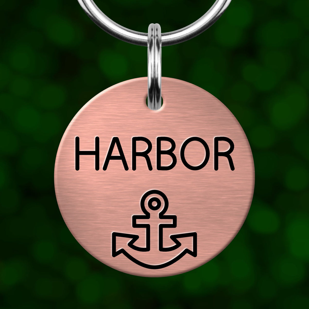A round metal keychain tag with the word "HARBOR" printed on it, along with an anchor symbol.