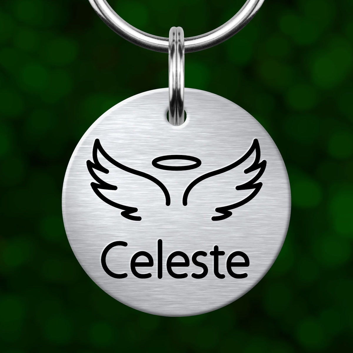 A round metal pet tag with a winged symbol and the name "Celeste" printed on it.